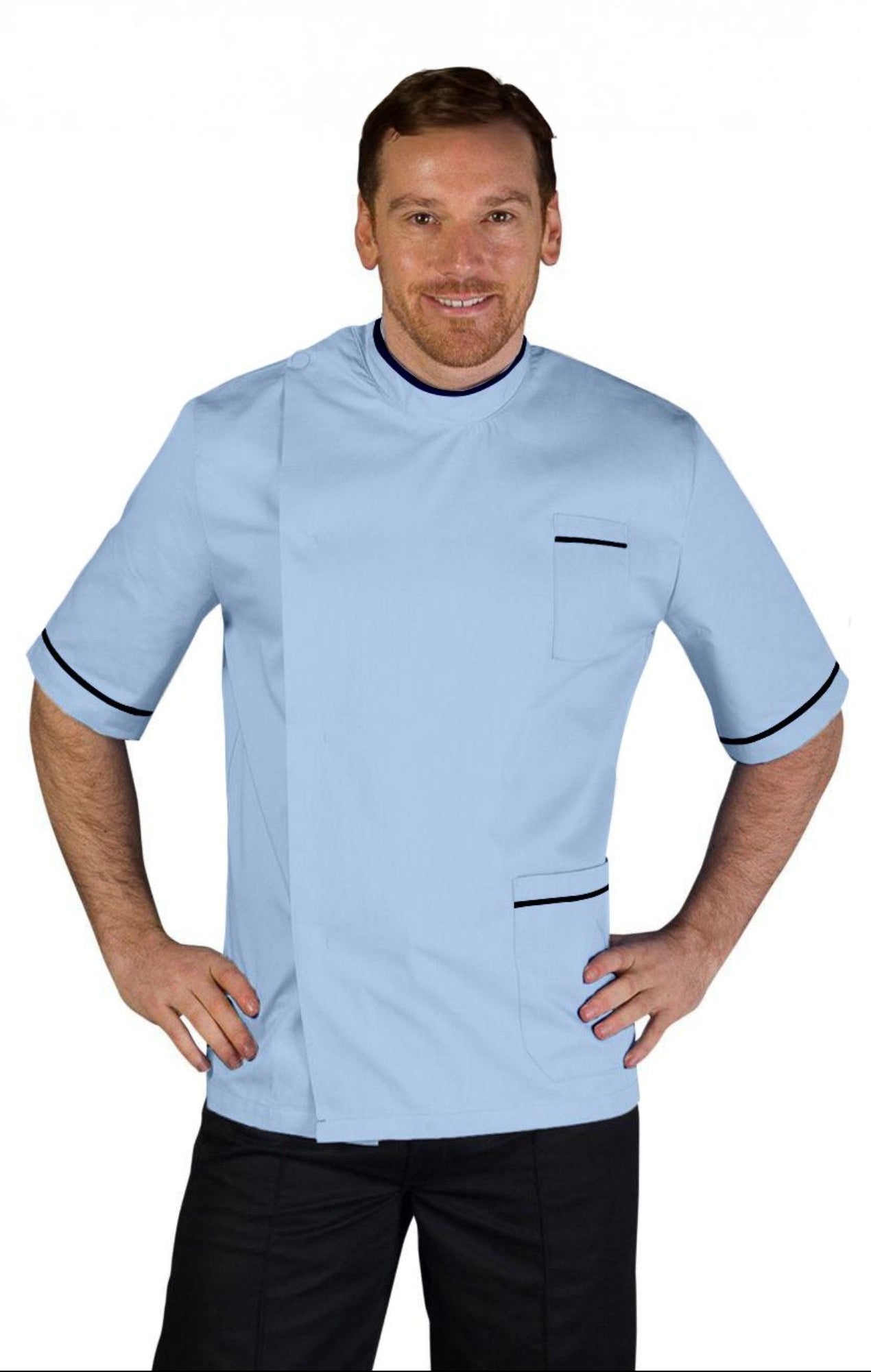 A man wearing a blue, short-sleeved, asymmetrical stud front tunic with contrasting black trim on the neck and sleeves, a left hip pocket, and a left breast pocket. The tunic features a half belt back detail and is vented on the back for ease of movement.