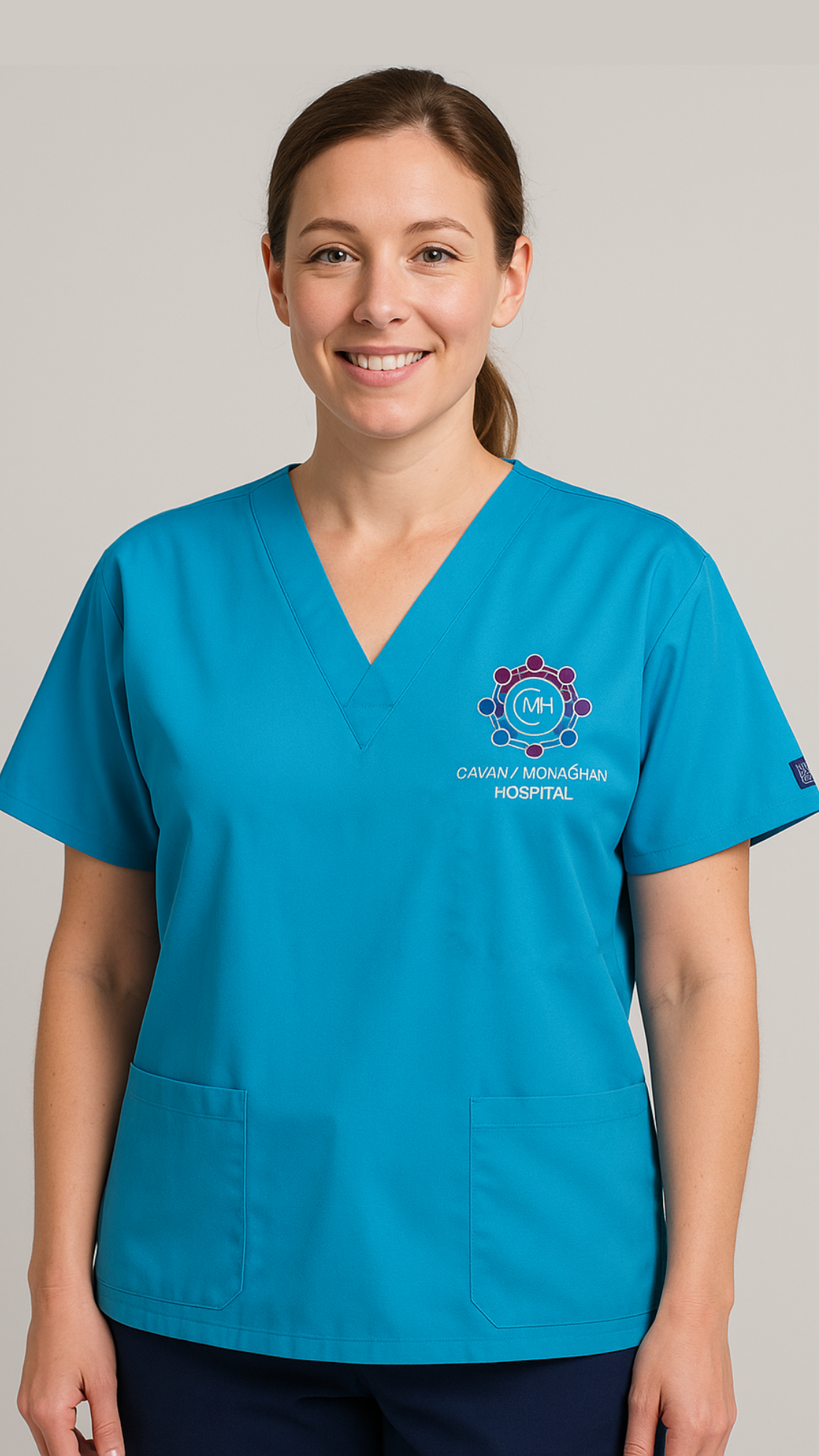 Person wearing a blue scrub top with a hospital logo on a plain background