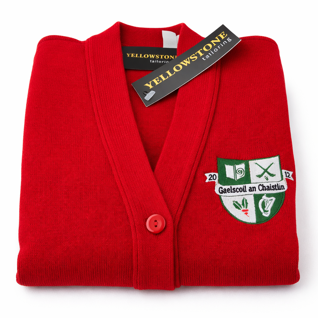 Folded red cardigan with a crest and 'Yellowstone Tailoring' tag on a white background