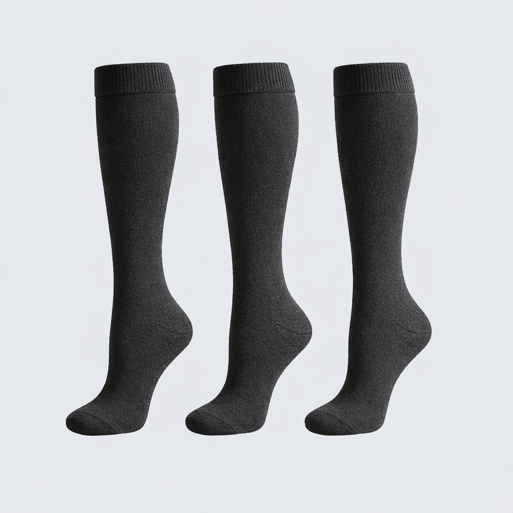 Three pairs of gray knee-high socks on a light gray background