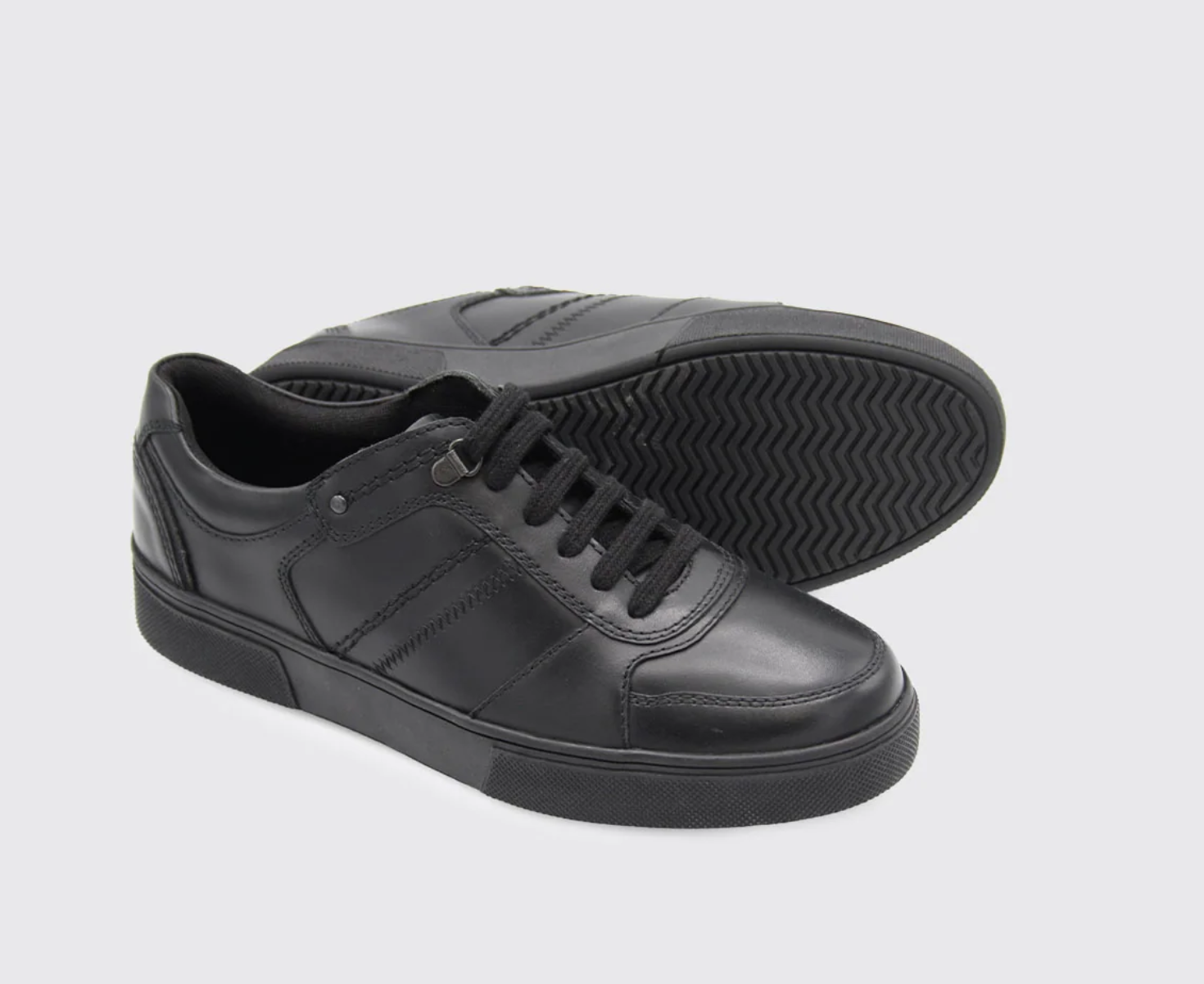 Black leather sneakers on a light gray background