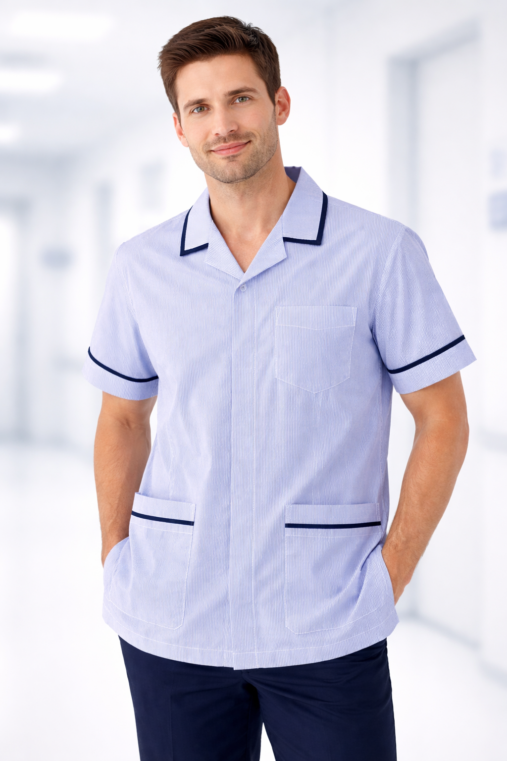 Man wearing a light blue uniform with dark trim against a blurred indoor background